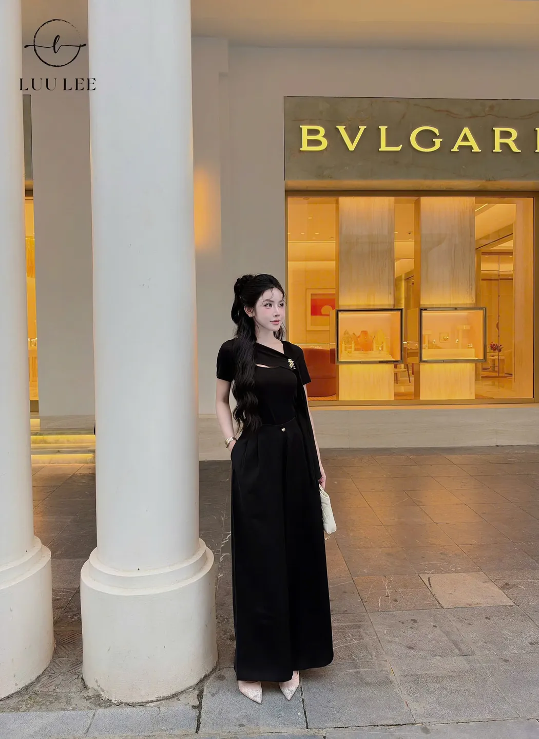 Góc nhìn khác của trang phục đen với quần rộng và chi tiết vạt áo.